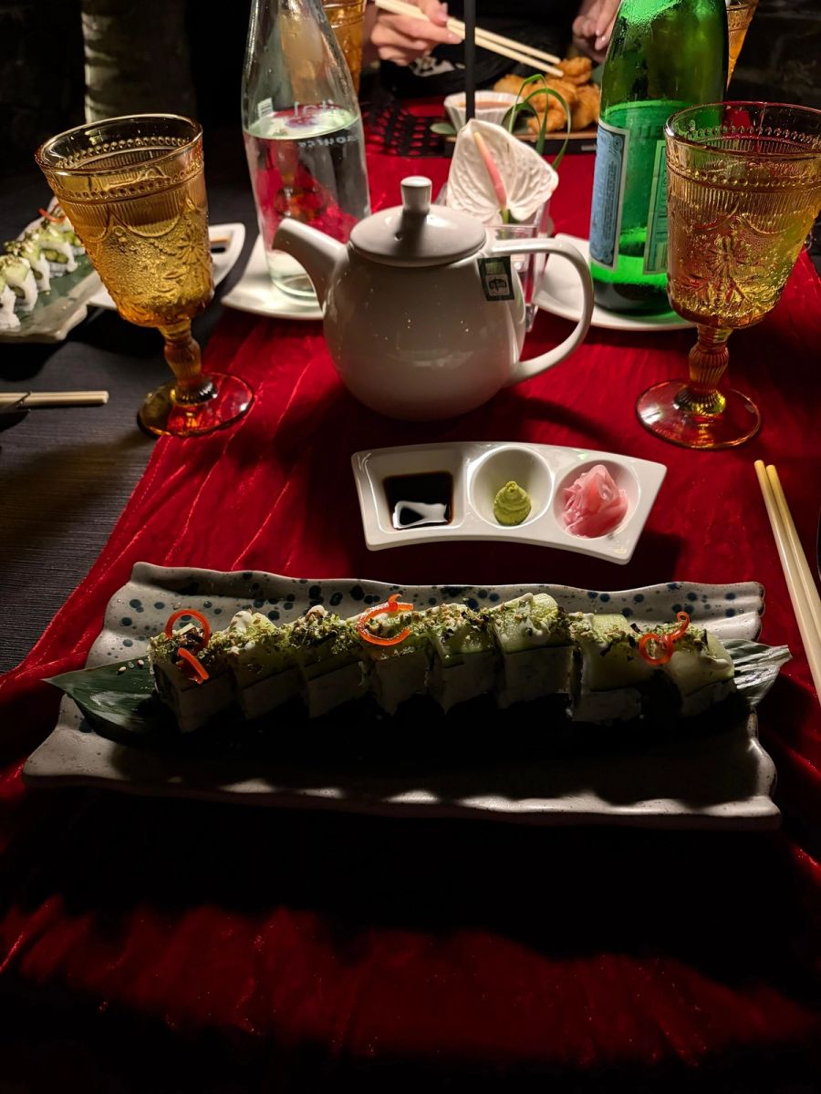 Sushi roll plated on a long leaf with sake teapot and amber glasses at the Asian restaurant, Beachcomber Royal Palm