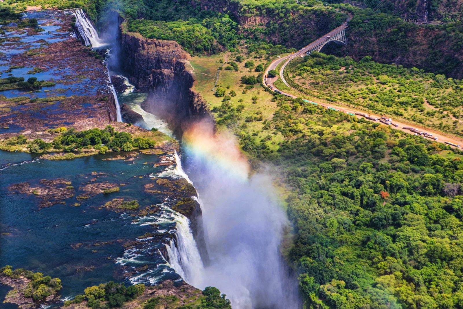 An aerial view of Victoria Falls with a rainbow in the spray